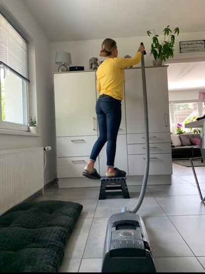 Saugschlauch dehnbar Frau mit Staubsaugerschlauch