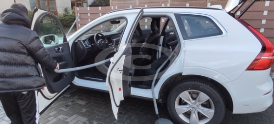 Staubsaugerschlauch Staubnatter beim PKW reinigen Mann saugt mit Staubnatter, Auto aus.